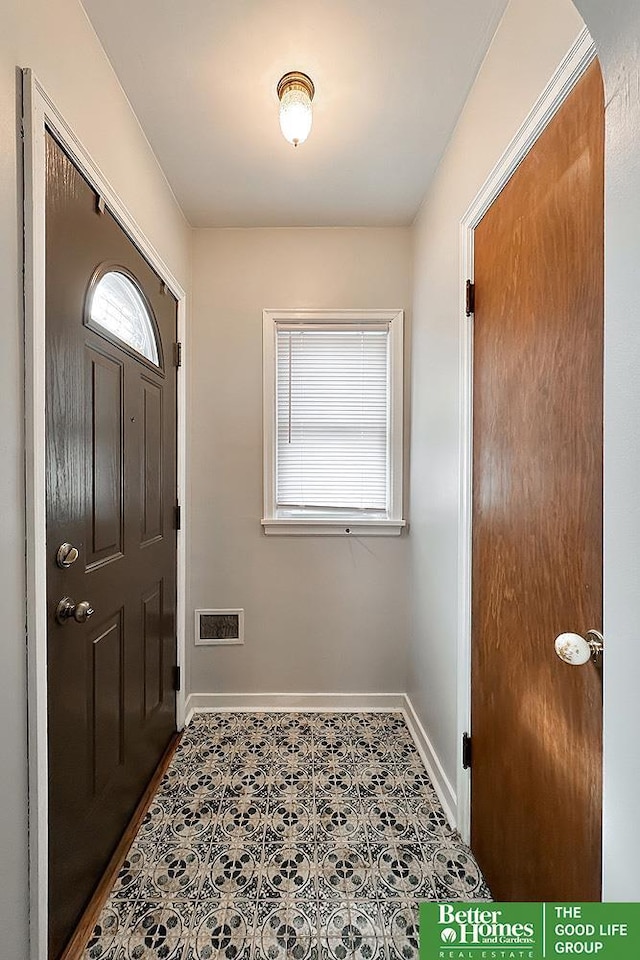 tiled entrance foyer with plenty of natural light, visible vents, and baseboards