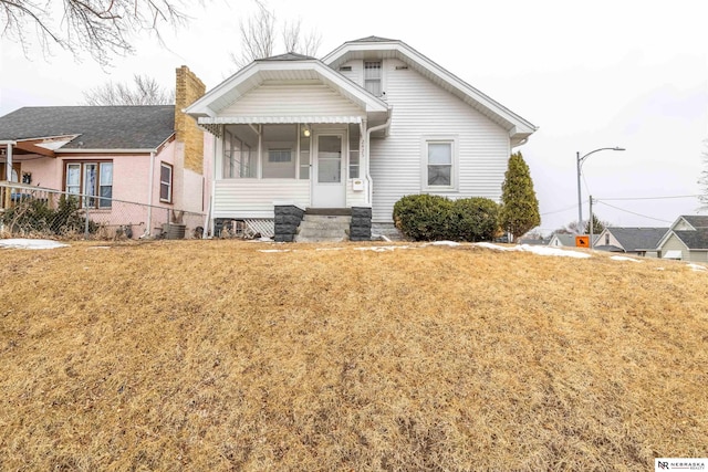 bungalow-style house featuring a front lawn and a chimney