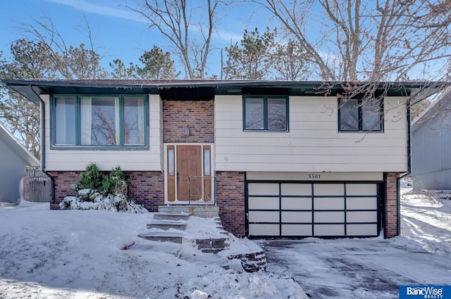 bi-level home featuring a garage and brick siding