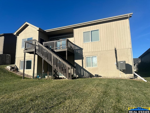 back of property featuring stairs, a yard, brick siding, and a deck