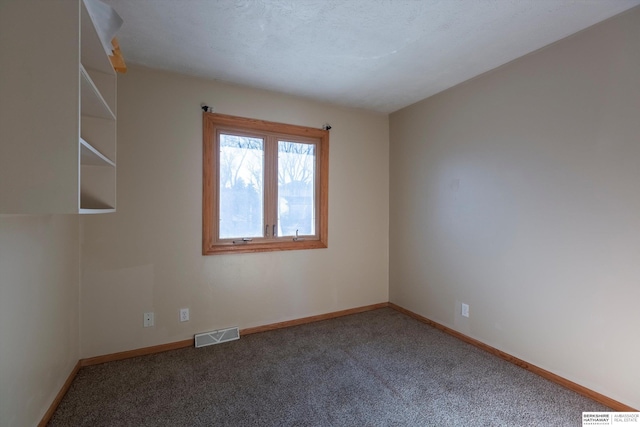 unfurnished room featuring carpet floors, visible vents, and baseboards