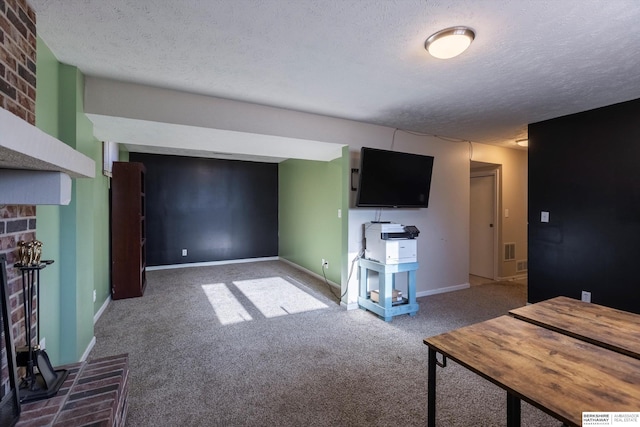 unfurnished living room featuring carpet, visible vents, a brick fireplace, a textured ceiling, and baseboards