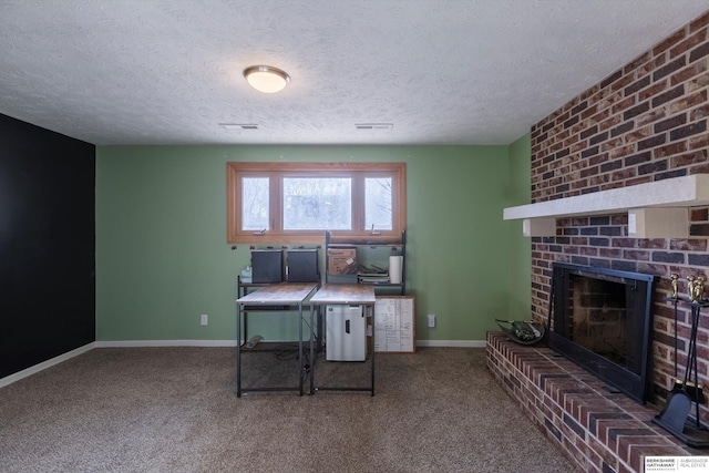 carpeted home office featuring a brick fireplace, a textured ceiling, and baseboards