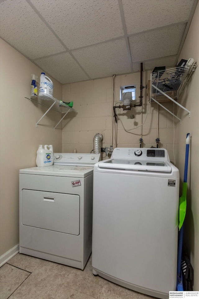 laundry room with laundry area, washer and clothes dryer, and concrete block wall