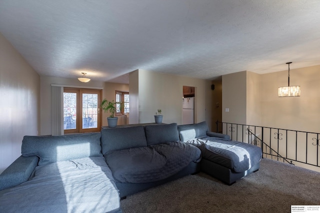 carpeted living area featuring a notable chandelier