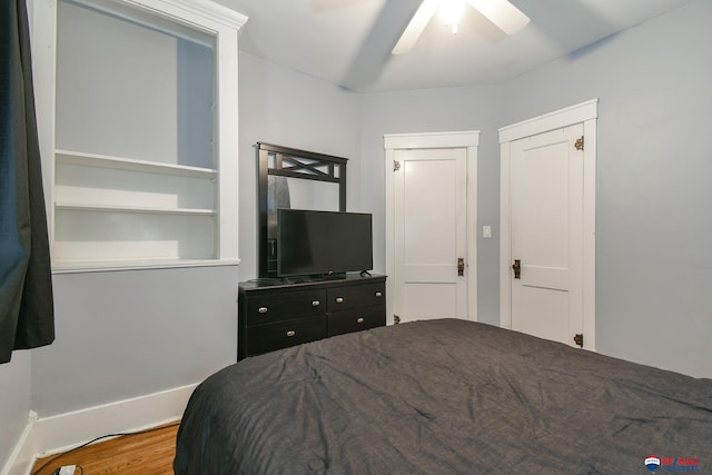 bedroom featuring ceiling fan, wood finished floors, and baseboards