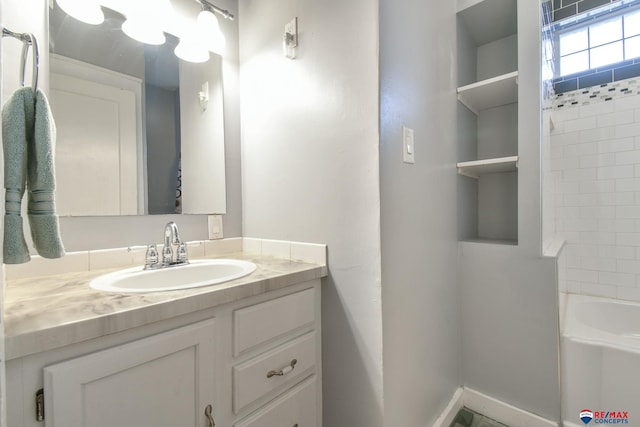 full bath with vanity and baseboards