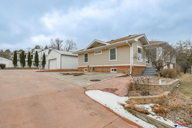 view of front of home with a garage, driveway, and an outdoor structure