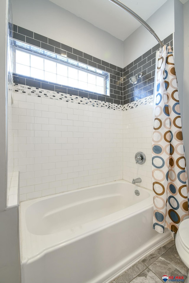 bathroom with toilet and shower / tub combo