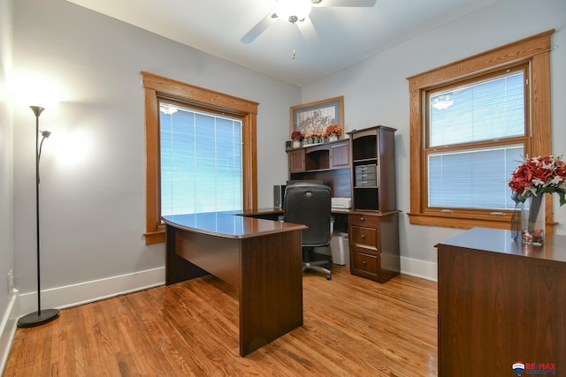 home office featuring light wood-style floors, ceiling fan, and baseboards