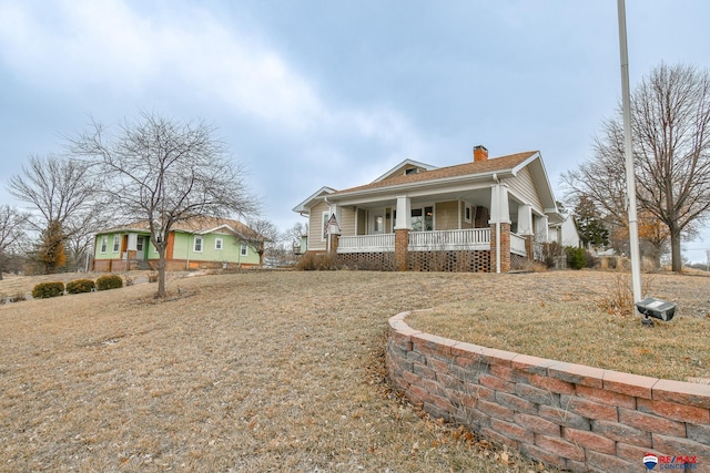 view of front of property with a chimney and a porch