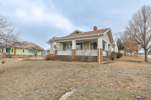 bungalow-style house featuring covered porch and a chimney