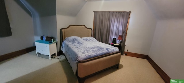 bedroom with carpet, baseboards, and vaulted ceiling