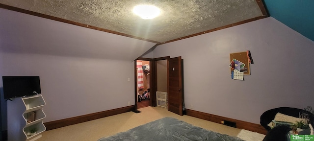 bedroom with vaulted ceiling, a textured ceiling, carpet, and baseboards