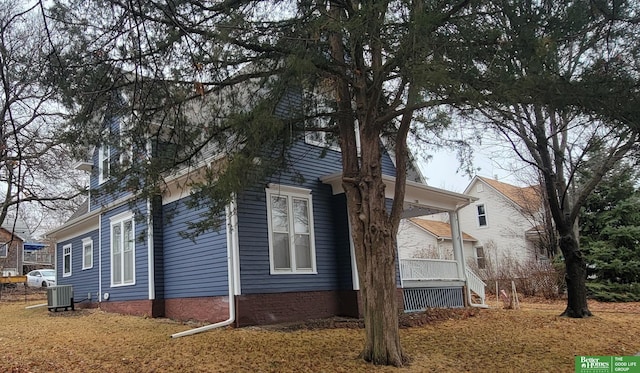 view of side of home with covered porch and cooling unit