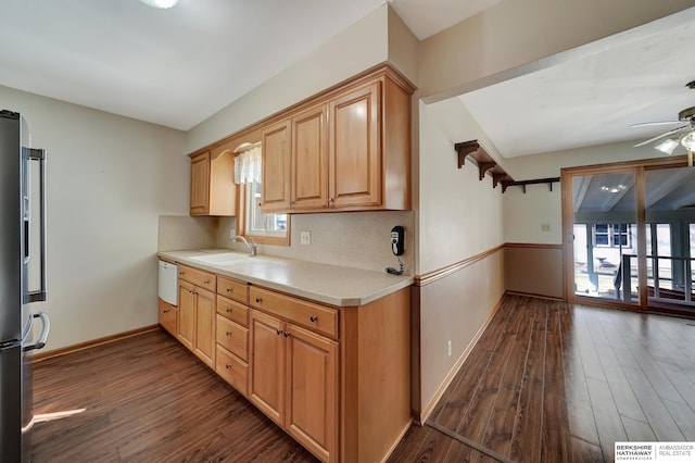 kitchen featuring a sink, dark wood-style floors, light countertops, baseboards, and high end refrigerator