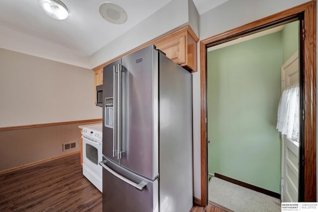 kitchen featuring visible vents, light brown cabinets, a wainscoted wall, appliances with stainless steel finishes, and dark wood-style floors