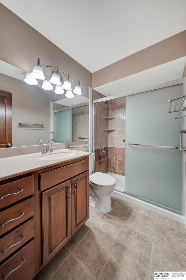 bathroom featuring vanity, tile patterned floors, toilet, and a stall shower