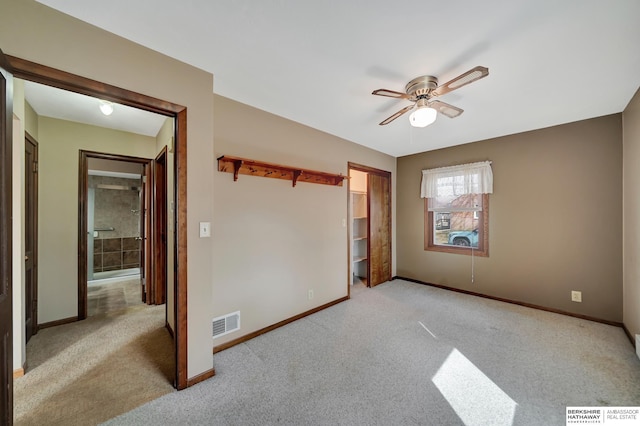 carpeted empty room featuring a ceiling fan, baseboards, and visible vents