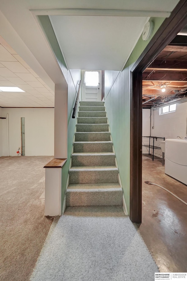 staircase featuring washer / clothes dryer and concrete floors