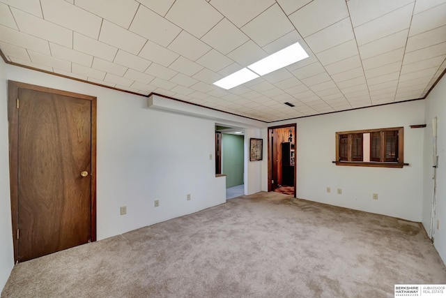 empty room featuring visible vents, carpet flooring, and crown molding