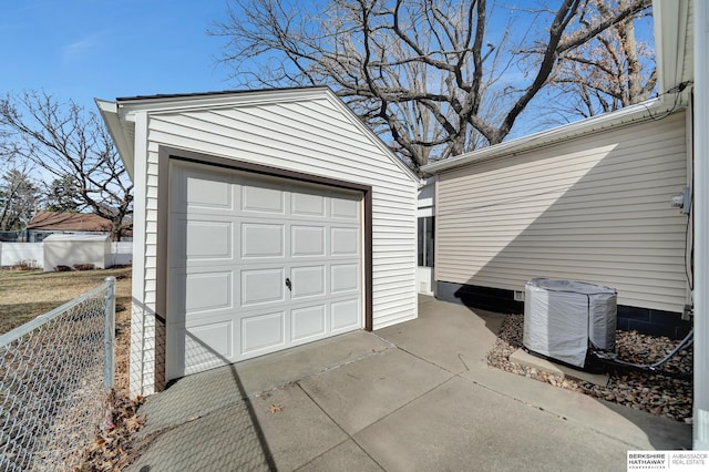 detached garage with concrete driveway and fence