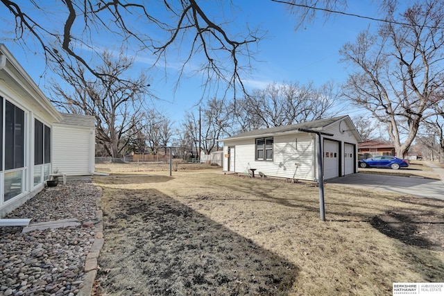 view of home's exterior featuring a garage, a sunroom, and fence