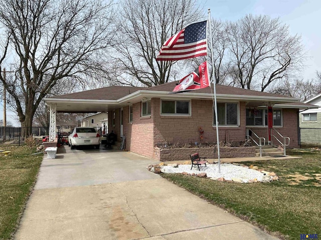 view of front of house with a carport, brick siding, driveway, and a front lawn