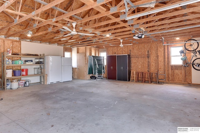 garage featuring freestanding refrigerator and a garage door opener