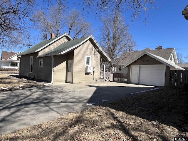 view of property exterior with driveway, a garage, and fence