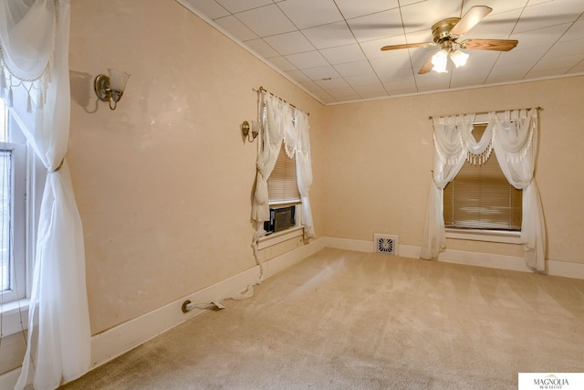 interior space featuring carpet floors, visible vents, a ceiling fan, cooling unit, and baseboards