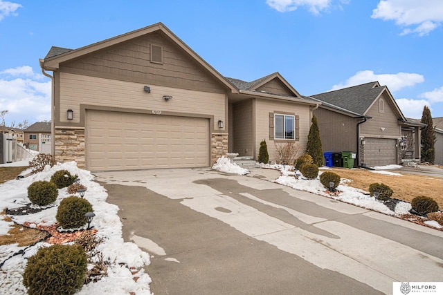 single story home with stone siding, an attached garage, and concrete driveway