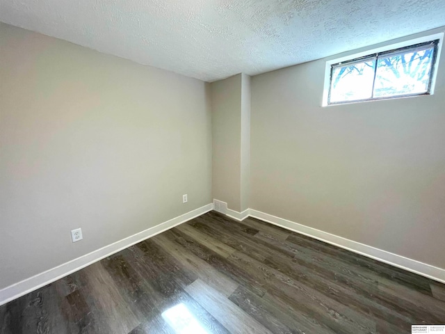 interior space featuring visible vents, a textured ceiling, baseboards, and dark wood-style flooring