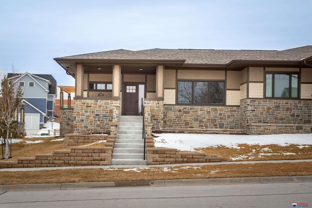 prairie-style house featuring stone siding and a shingled roof