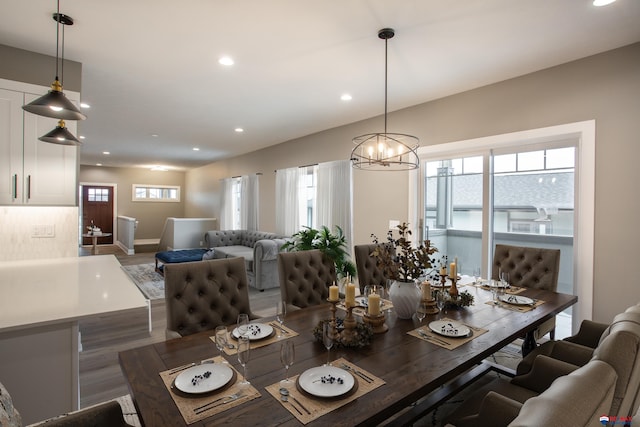 dining area with recessed lighting, baseboards, a notable chandelier, and wood finished floors