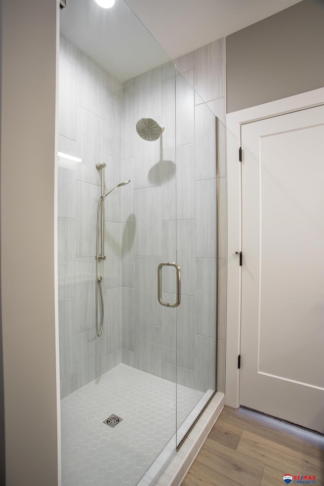 bathroom featuring wood finished floors and a stall shower