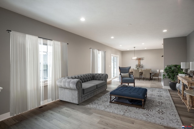 living room with recessed lighting, wood finished floors, visible vents, and baseboards