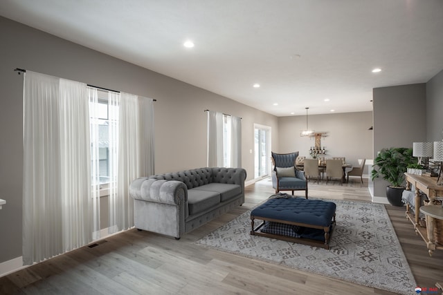 living room with visible vents, recessed lighting, baseboards, and wood finished floors