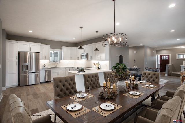 dining room with recessed lighting and light wood finished floors