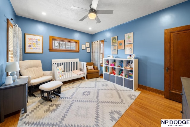 bedroom featuring a ceiling fan, a textured ceiling, wood finished floors, recessed lighting, and baseboards