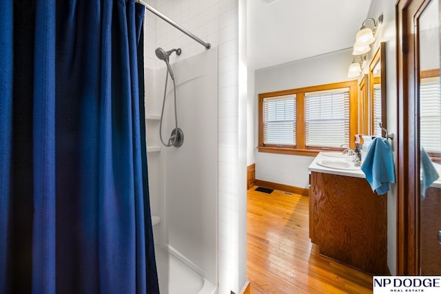 full bath with vanity, a shower with curtain, and hardwood / wood-style floors