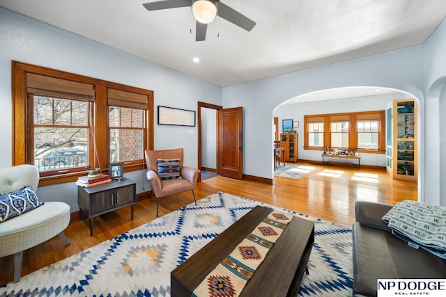 living room featuring wood finished floors, recessed lighting, arched walkways, baseboards, and ceiling fan