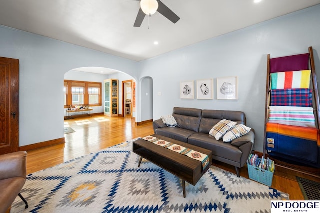 living area featuring a ceiling fan, wood finished floors, baseboards, recessed lighting, and arched walkways