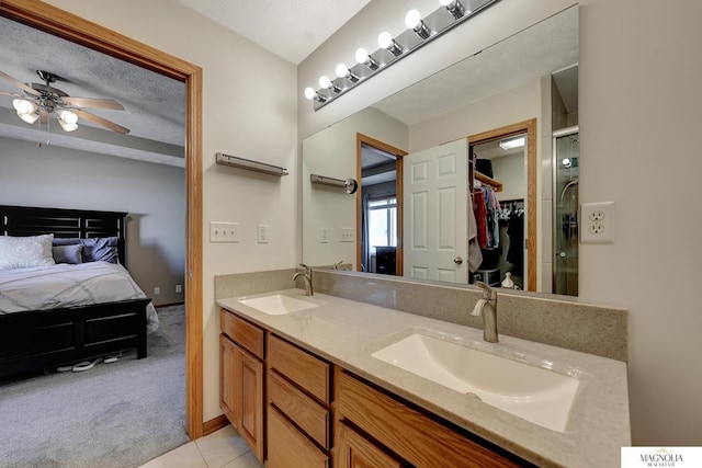 full bathroom with double vanity, a textured ceiling, ensuite bath, and a sink