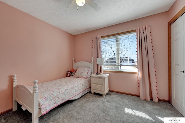 bedroom with light carpet, a textured ceiling, baseboards, and a ceiling fan