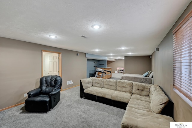 living area with carpet flooring, baseboards, visible vents, and a textured ceiling