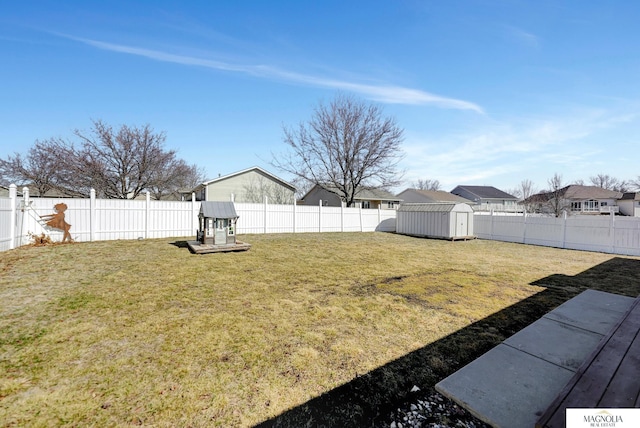 view of yard with an outbuilding, a storage unit, and a fenced backyard