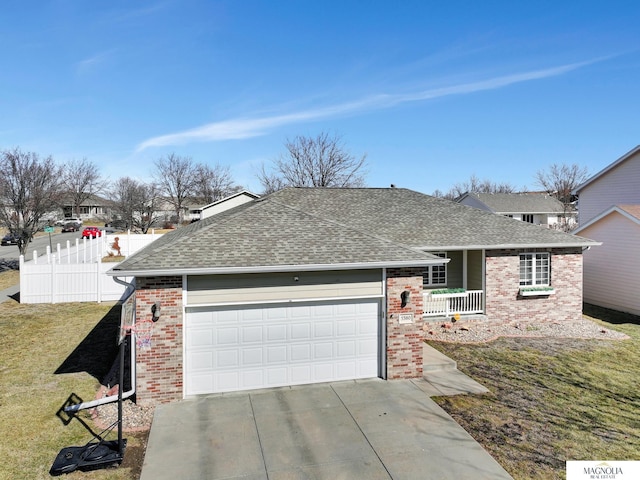 view of front facade featuring fence, roof with shingles, concrete driveway, a front yard, and brick siding