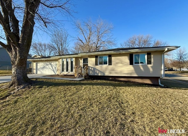 ranch-style home featuring a garage, driveway, and a front lawn