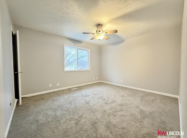 carpeted empty room with ceiling fan, baseboards, and a textured ceiling